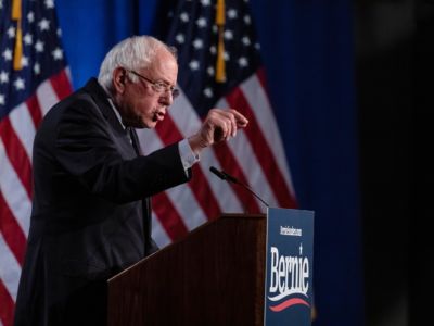 Bernie Sanders points towards the audience while speaking at a podium