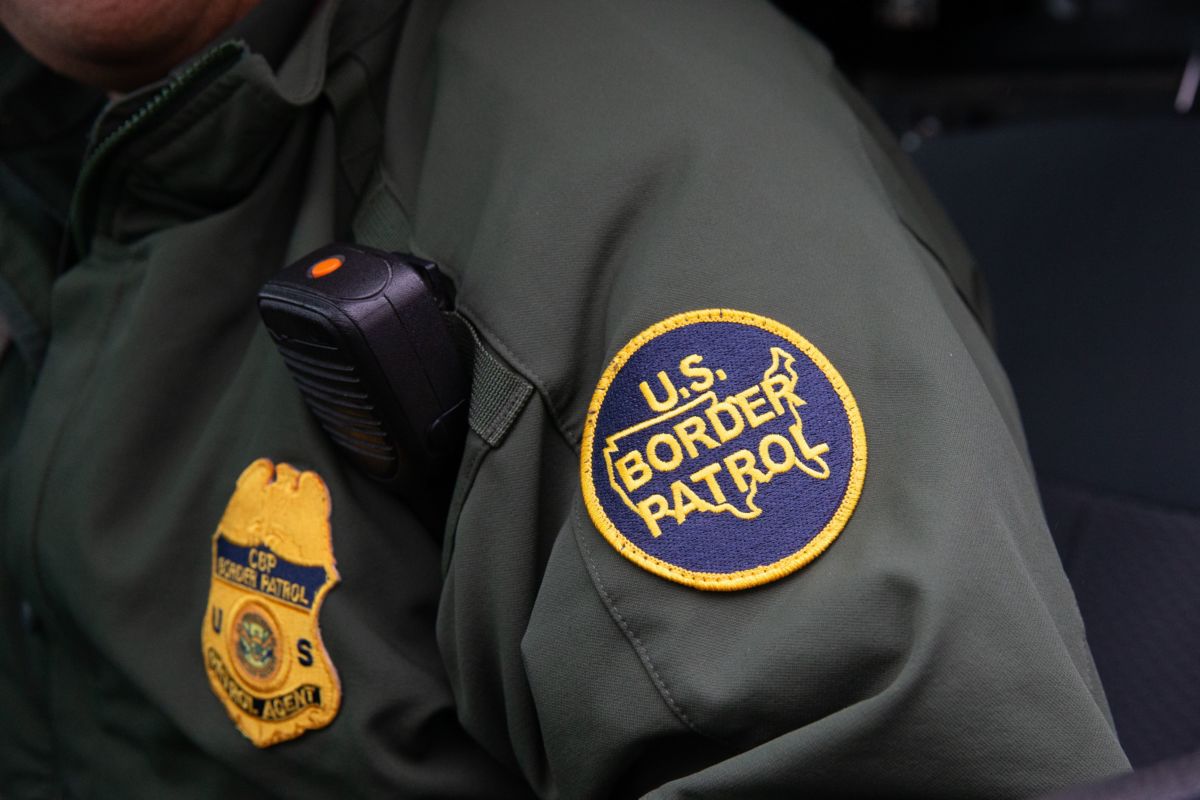 A border patrol officer wears a patch reading "US BORDER PATROL" on their sleeve