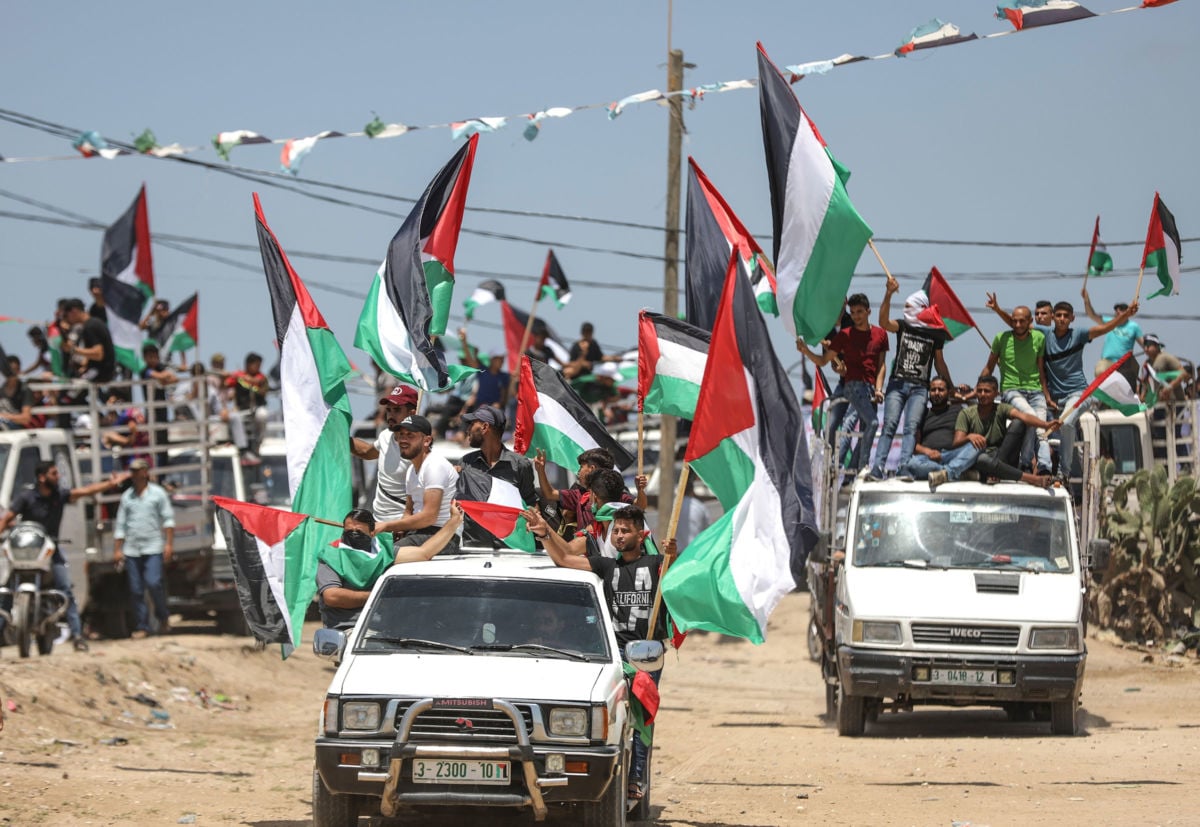 Palestinians holding Palestinian flags protest Israel's ongoing 13-year blockade, in Gaza City, Gaza, on July 22, 2019.
