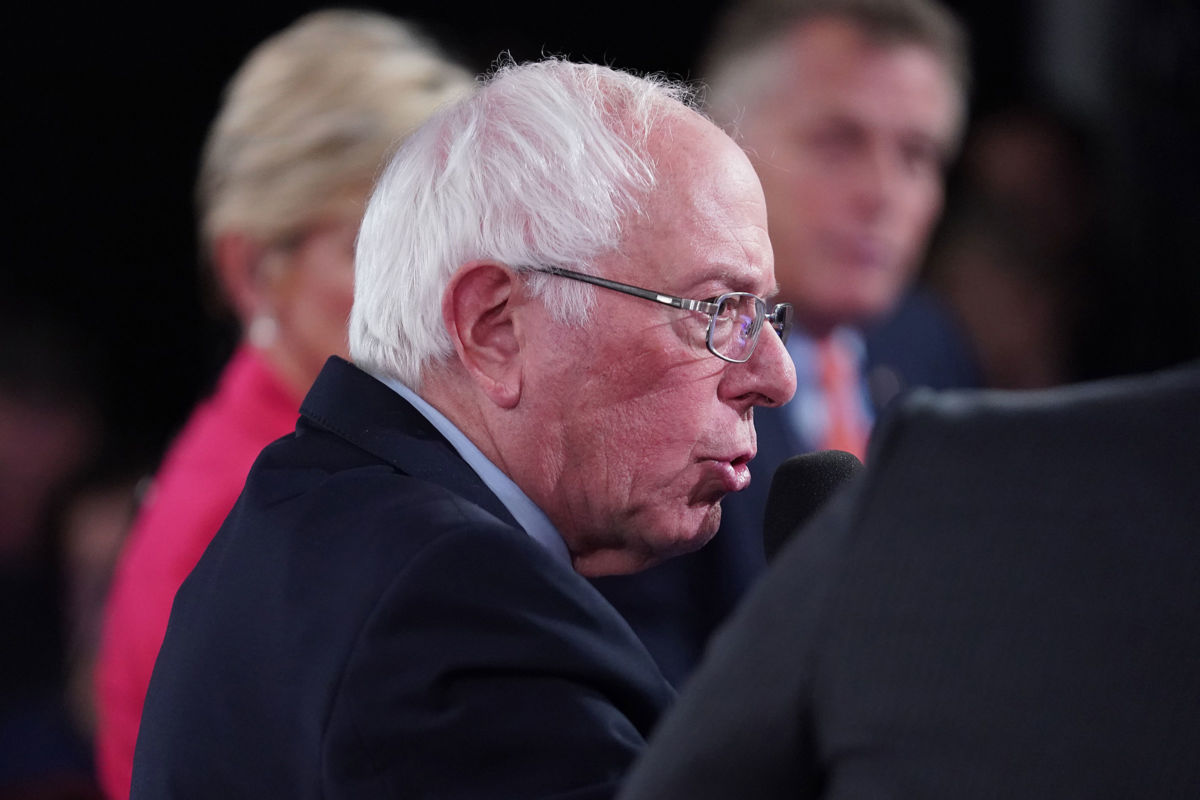 Bernie Sanders stands in a row of other candidates and speaks