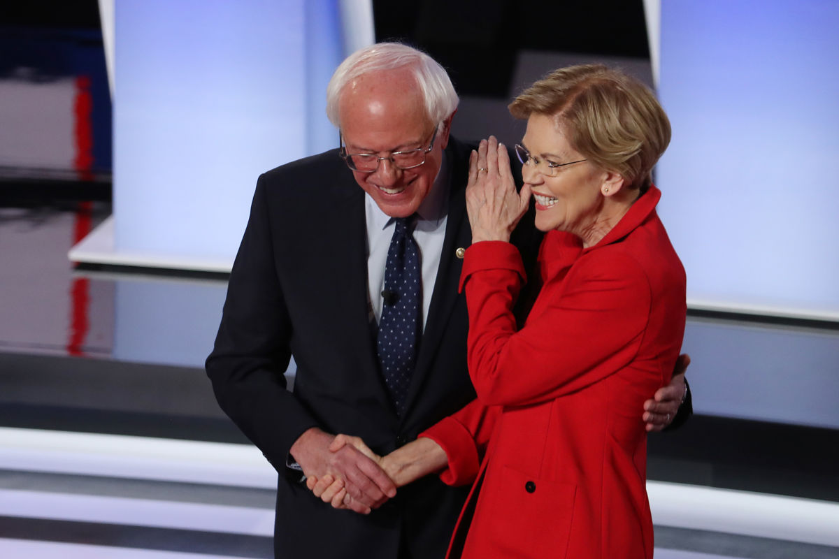 Bernie Sanders and Elizabeth Warren embrace while smiling