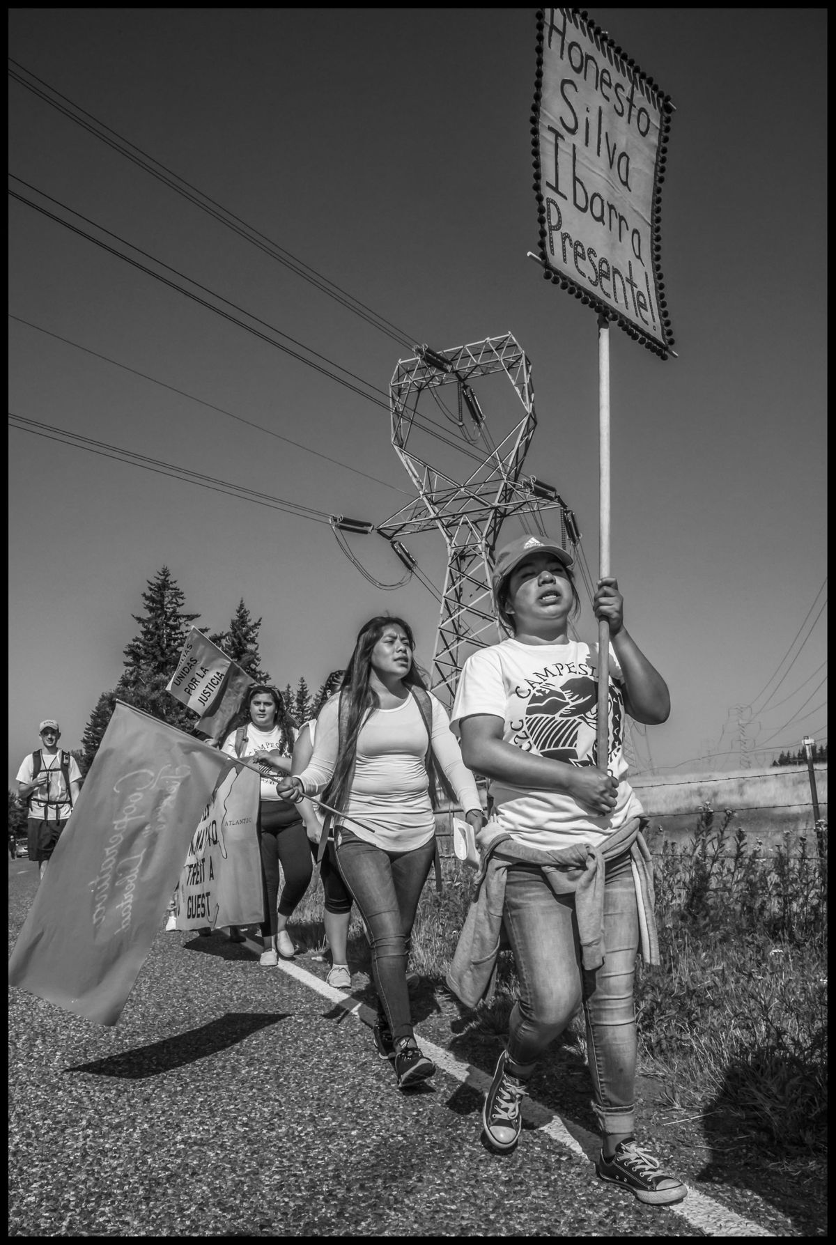 A marcher carries the banner remembering Honesto Silva Ibarra, an H-2A worker who died in a field in 2017.