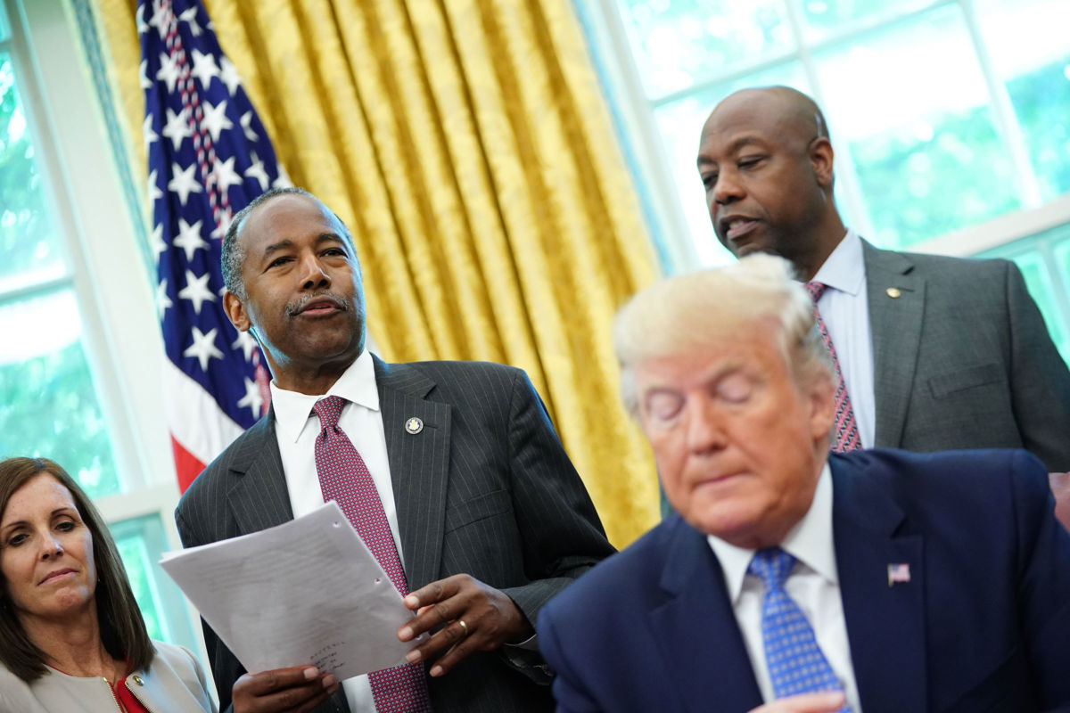 Ben Carson stands behind Donald Trump and speaks