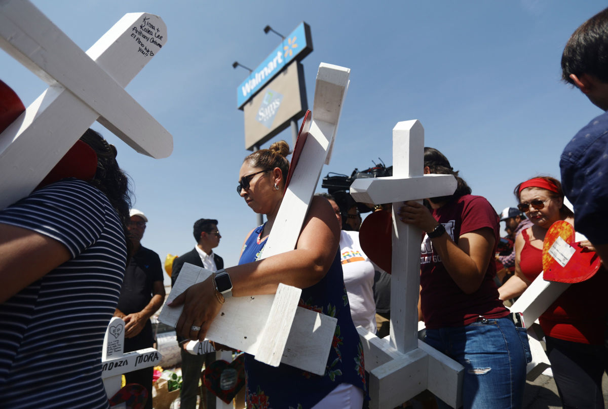 Volunteers carry handmade crosses memorializing the victims of a mass shooting to a makeshift memorial outside Walmart, where the shooting took place, on August 5, 2019, in El Paso, Texas.