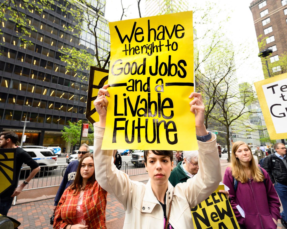 A protester holds a placard during the Sunrise NYC rally in support of the Green New Deal outside Sen. Chuck Schumer's New York City office, April 30, 2019.