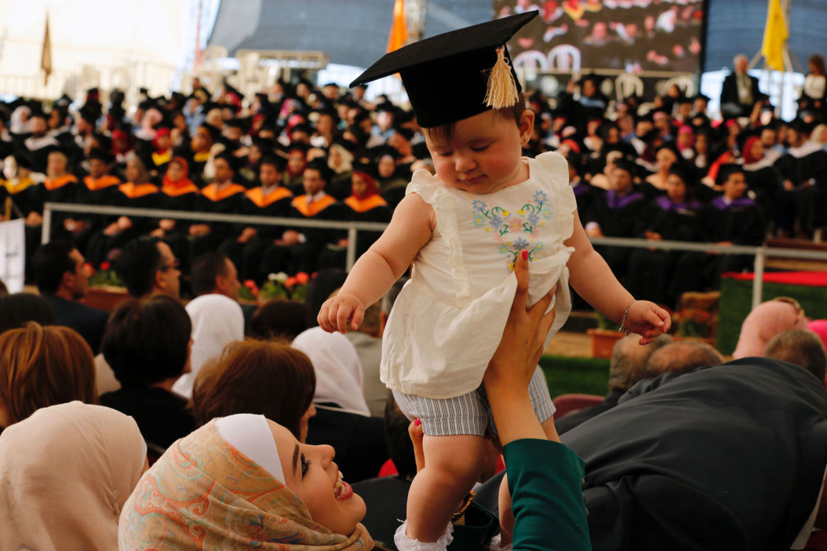 A Palestinian woman holds a baby wearing a cap during a graduation ceremony at Birzeit University in the West Bank town of Birzeit, near Ramallah, on May 20, 2016.