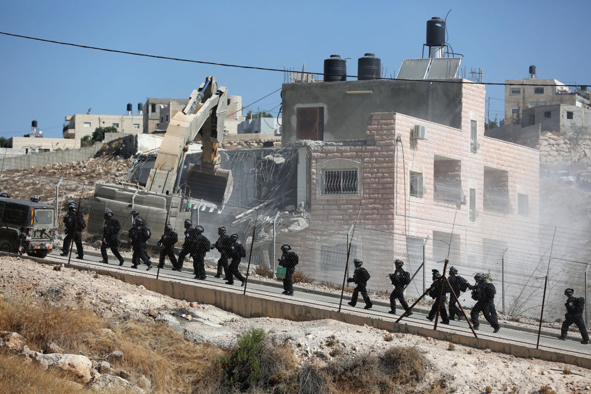 Israeli soldiers supervise the demolition of buildings belonging to Palestinians on the grounds that they are too close to the wire barriers that continue the separation wall in the Wadi al-Hummus neighborhood of East Jerusalem, July 22, 2019.