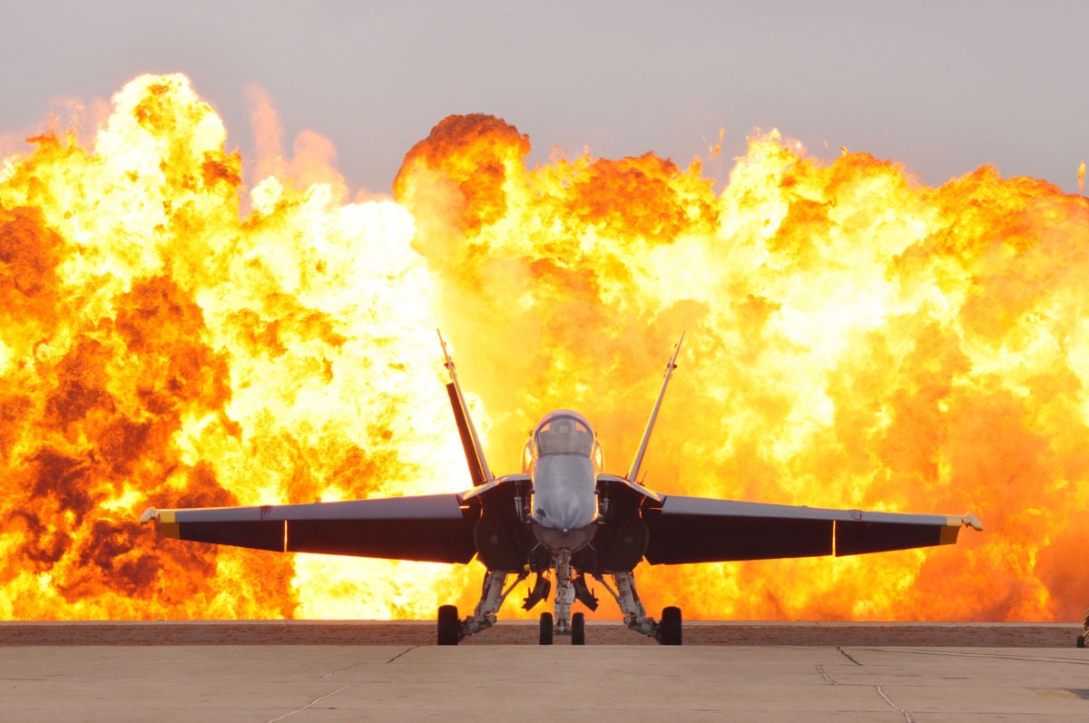 An F/A-18 Hornet aircraft sits on the flight line as a wall of fire detonates behind it during an air show at Marine Corps Air Station Miramar, California, October 3, 2010.