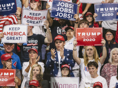 Trump supporters display signs and shout during a rally