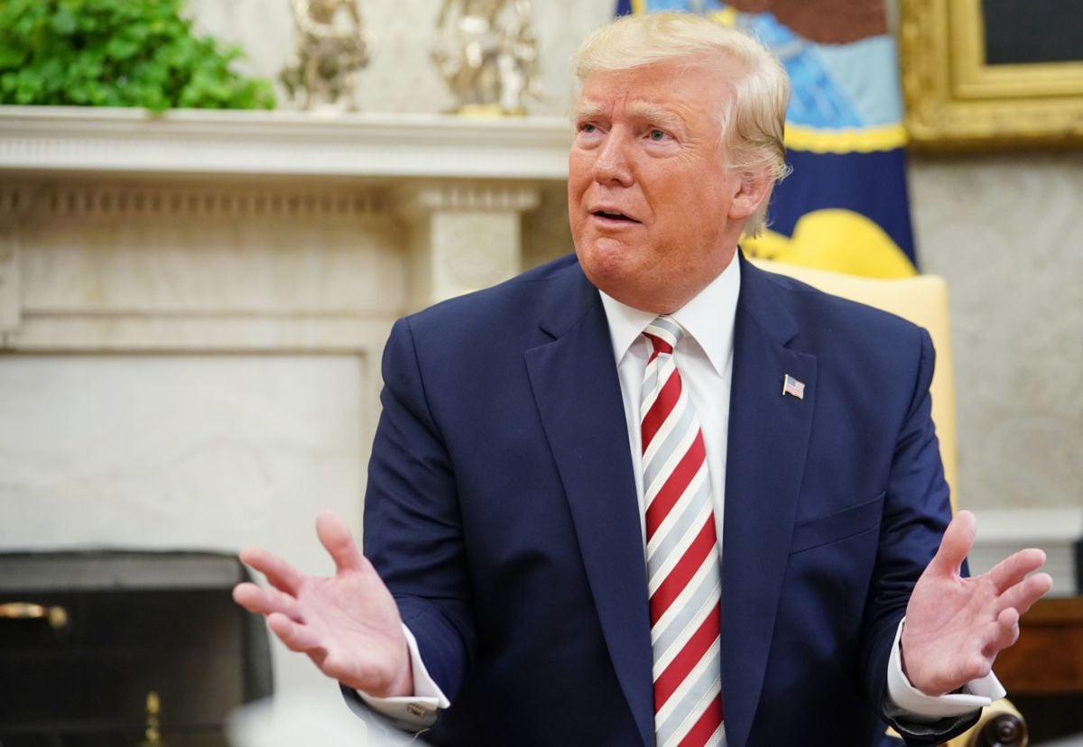 Donald Trump makes a face while seated in a chair