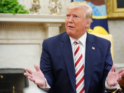 Donald Trump makes a face while seated in a chair