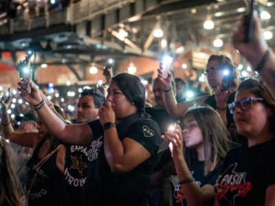 Attendees hold up the flashlights on their phones during a community memorial service for the 22 victims of the mass shooting, at Southwest University Park in El Paso, Texas, on August 14, 2019.