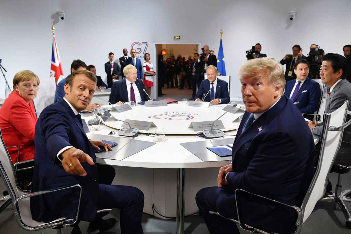 France's President Emmanuel Macron and President Trump pose for the media as they meet for the first working session of the G7 Summit on August 25, 2019, in Biarritz, France.