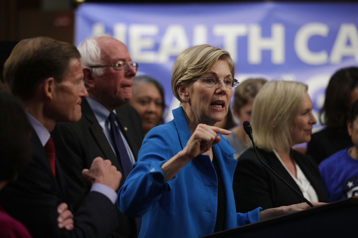 Sen. Elizabeth Warren speaks on health care as Sen. Bernie Sanders listens during an event September 13, 2017, on Capitol Hill in Washington, D.C.