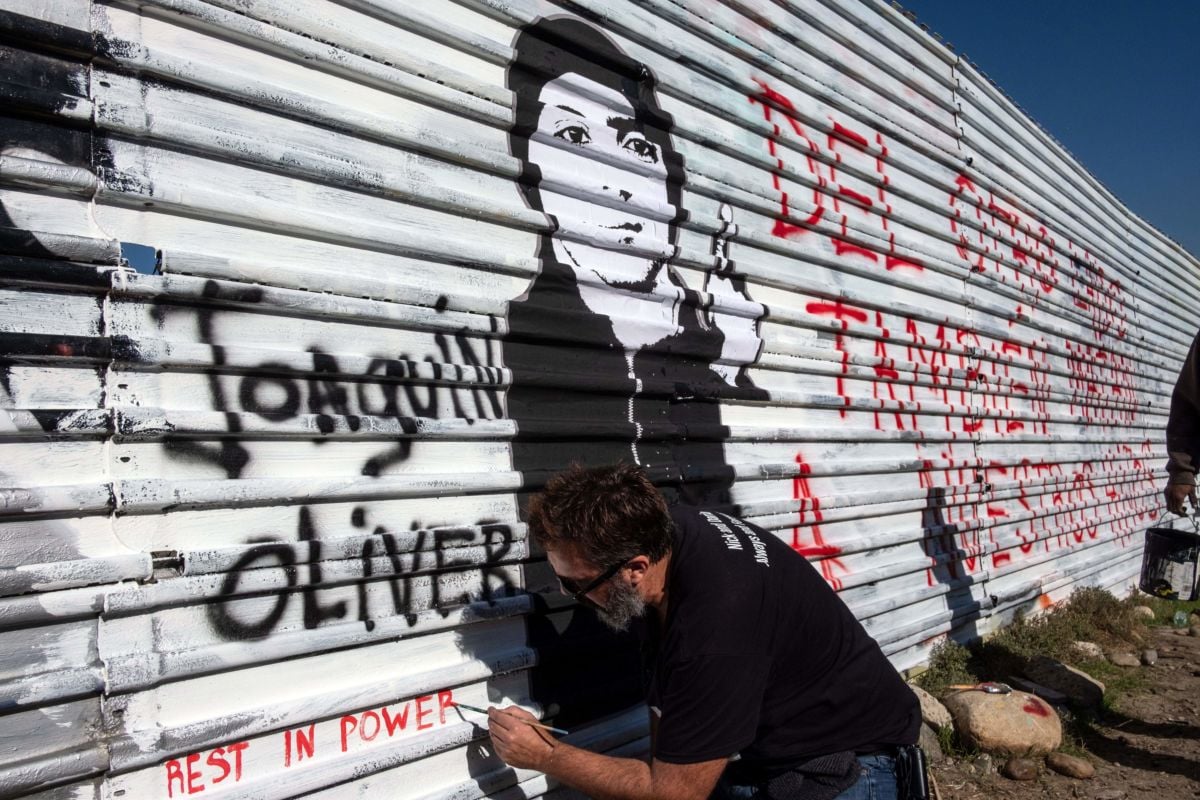 Venezuelan artist Manuel Oliver, father of slain Joaquin Oliver, works on a mural on the U.S.-Mexico border fence reading "On the other side they also kill our sons" in Tijuana, Baja California State, Mexico, on December 19, 2018.