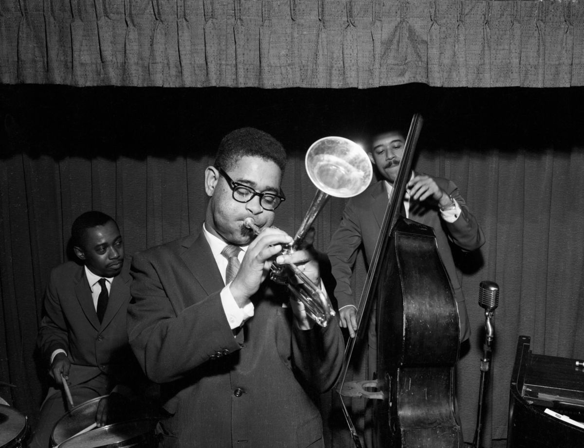 Jazz legend Dizzy Gillespie playing the trumpet with two other band members in 1955.