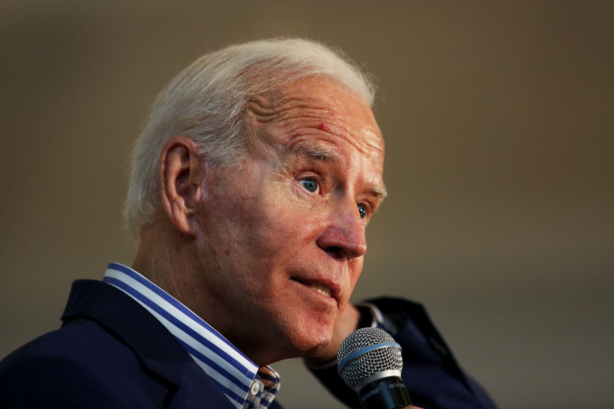 Joe Biden makes a face while speaking into a microphone