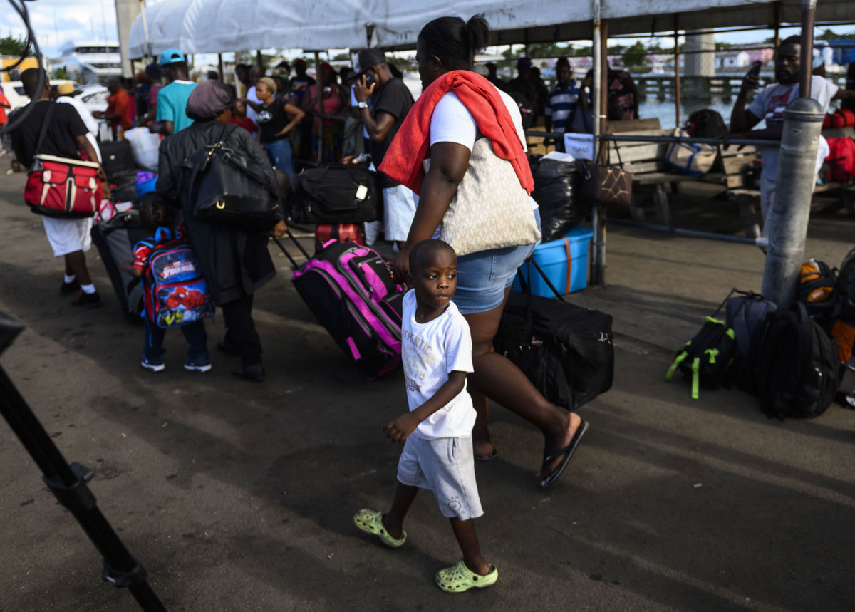 Evacuees in Nassau, Bahamas, wait on September 9, 2019, to board a bus heading to a shelter.