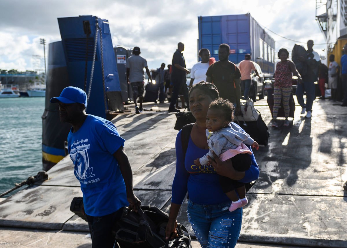 Evacuees in Nassau, Bahamas, wait on September 9, 2019, to board a bus heading to a shelter.