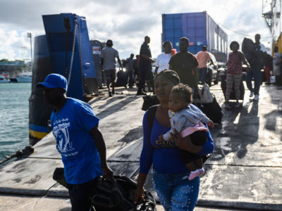 Evacuees in Nassau, Bahamas, wait on September 9, 2019, to board a bus heading to a shelter.