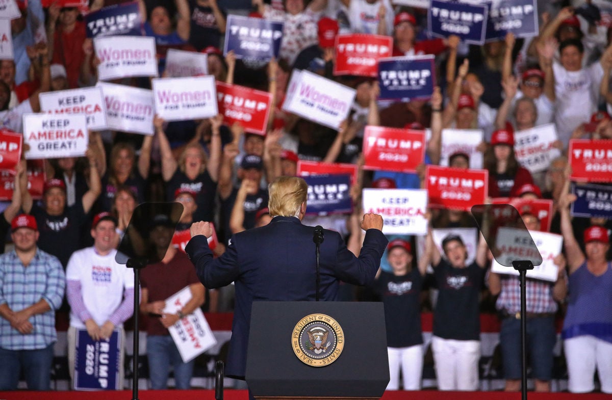 Donald Trump gestures at a crowd of supporters behind him