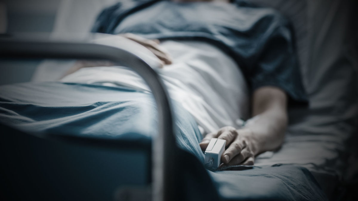 A patient lies in a hospital bed