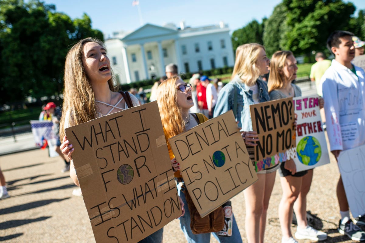 teens display signs opposing climate change outside of the white house