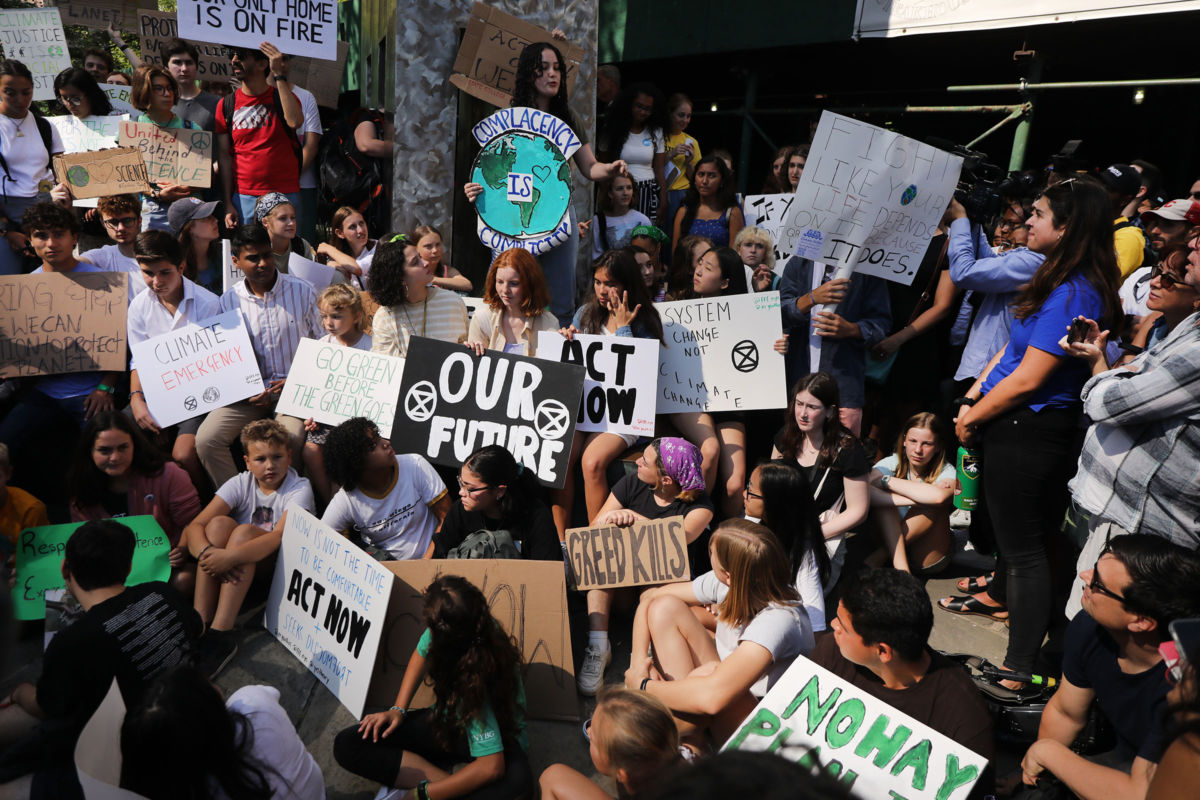 a group of climate activists display signs during a protest