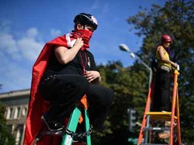 Activists chained to ladders take part in a blockade