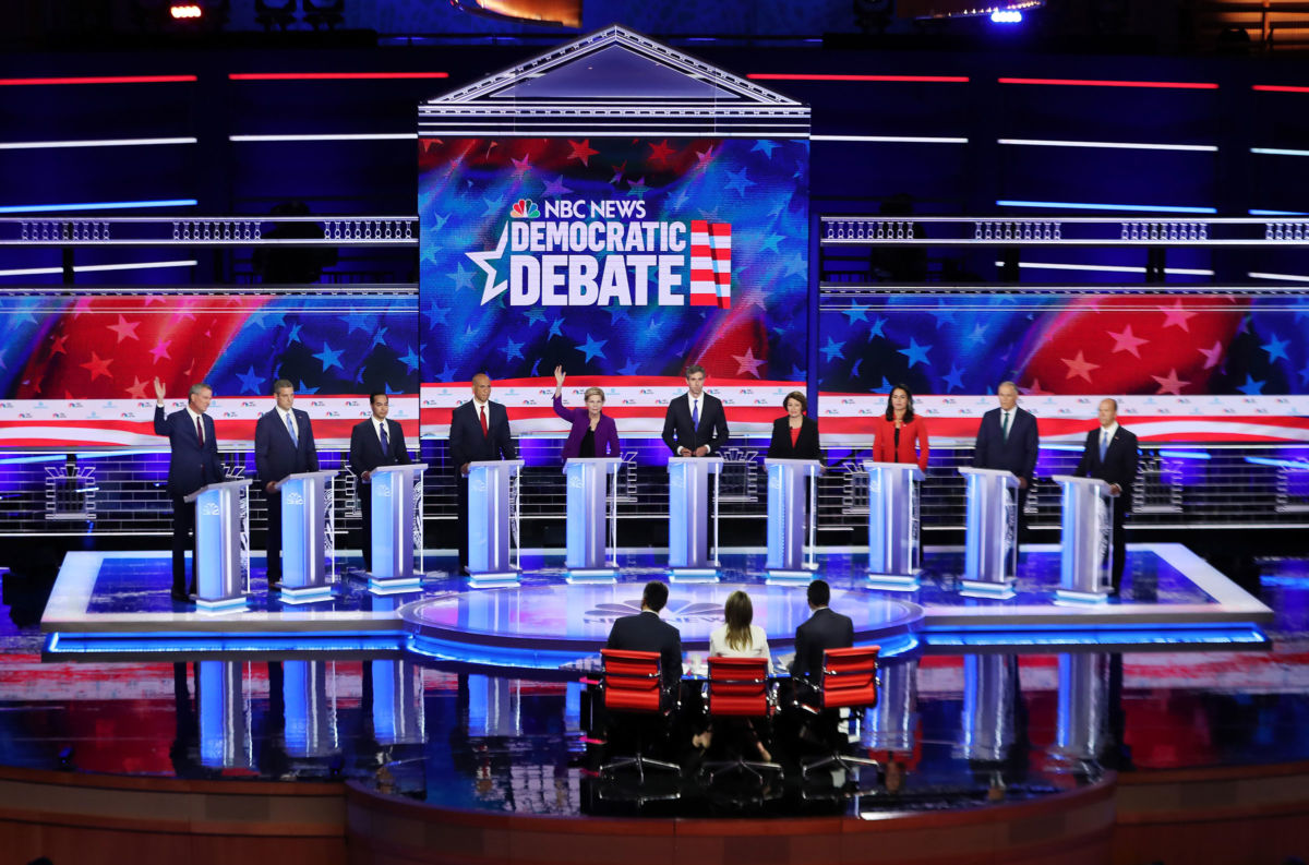 Democratic presidential candidates stand in line on the debate stage behind their respective podiums