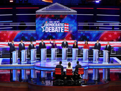 Democratic presidential candidates stand in line on the debate stage behind their respective podiums