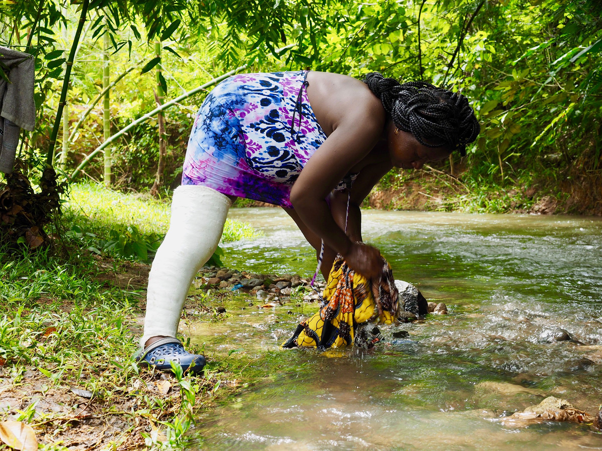 A woman washes clothing in the river