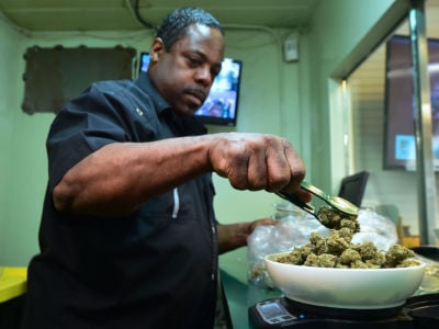 Eddie Irby weighs the marijuana at Virgil Grant's dispensary in Los Angeles, California