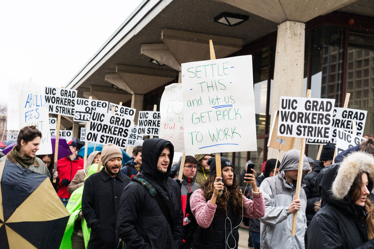 Grad student workers display signs during a protest