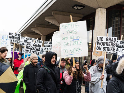 Grad student workers display signs during a protest