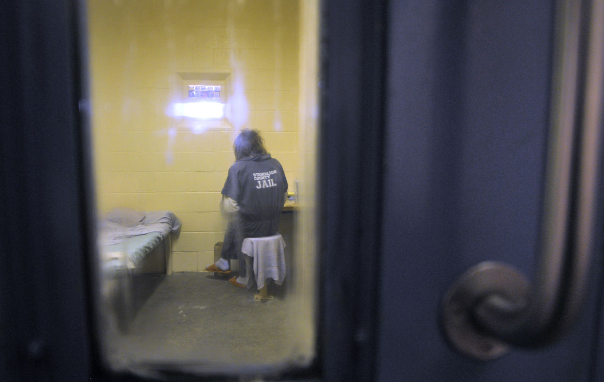 A prisoner sits in an isolation room in a prison