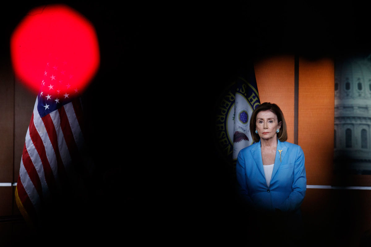 Nancy Pelosi stands at a podium