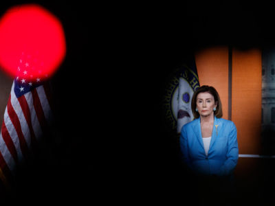 Nancy Pelosi stands at a podium