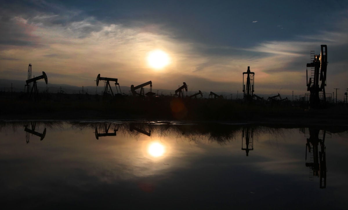 Oil pumps and equipment reflect on water in the South Belridge oil field in Kern County, the fourth largest oil field in California.