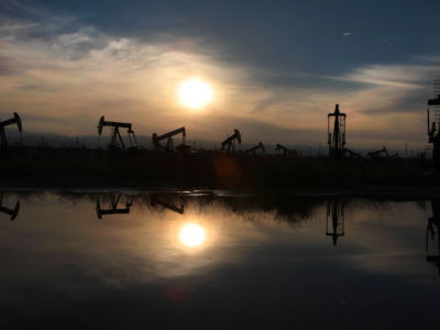 Oil pumps and equipment reflect on water in the South Belridge oil field in Kern County, the fourth largest oil field in California.