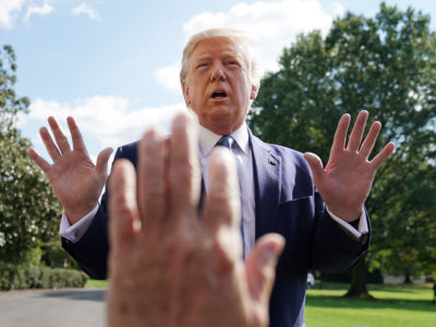 Someone raises their hand, as if to stop trump from speaking