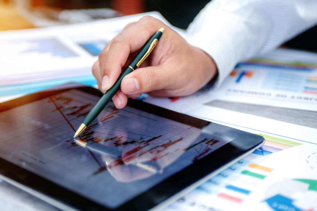 A man looks at a spreadsheet on a tablet computer