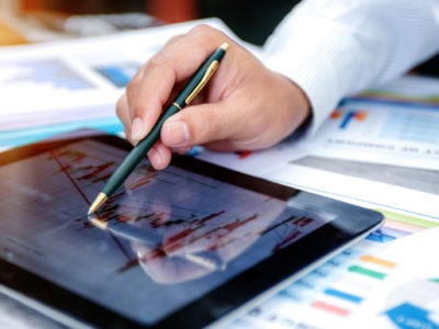 A man looks at a spreadsheet on a tablet computer