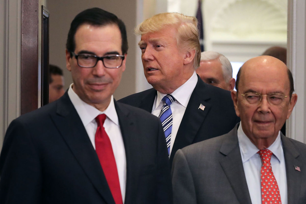 President Donald Trump arrives for a signing ceremony with Treasury Secretary Steven Mnuchin (L) and Commerce Secretary Wilbur Ross in the Roosevelt Room at the White House, March 8, 2018, in Washington, D.C.