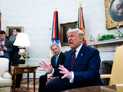 Donald Trump shouts while seated in the Oval Office