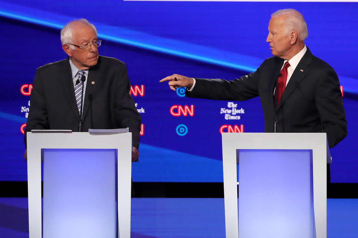 Joe Biden points a finger at Bernie Sanders on the debate stage