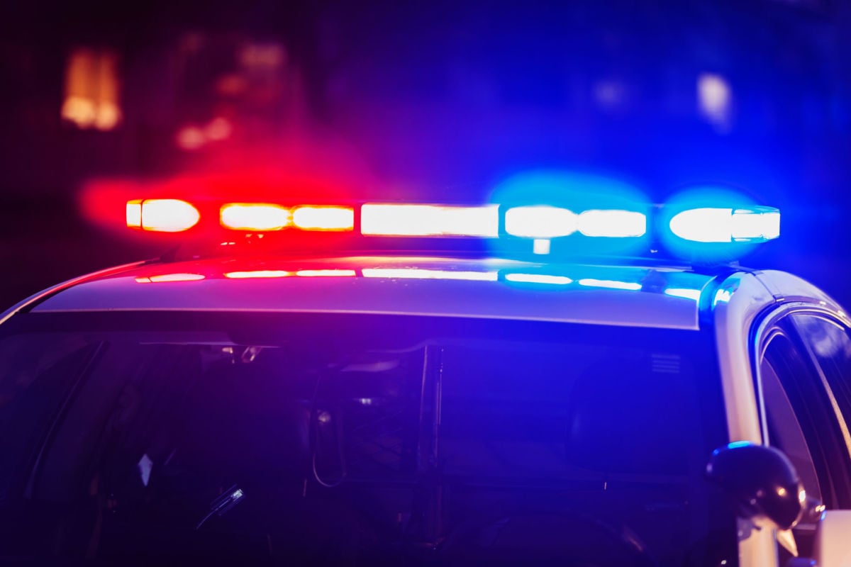 Red and blue lights flash from atop a police car