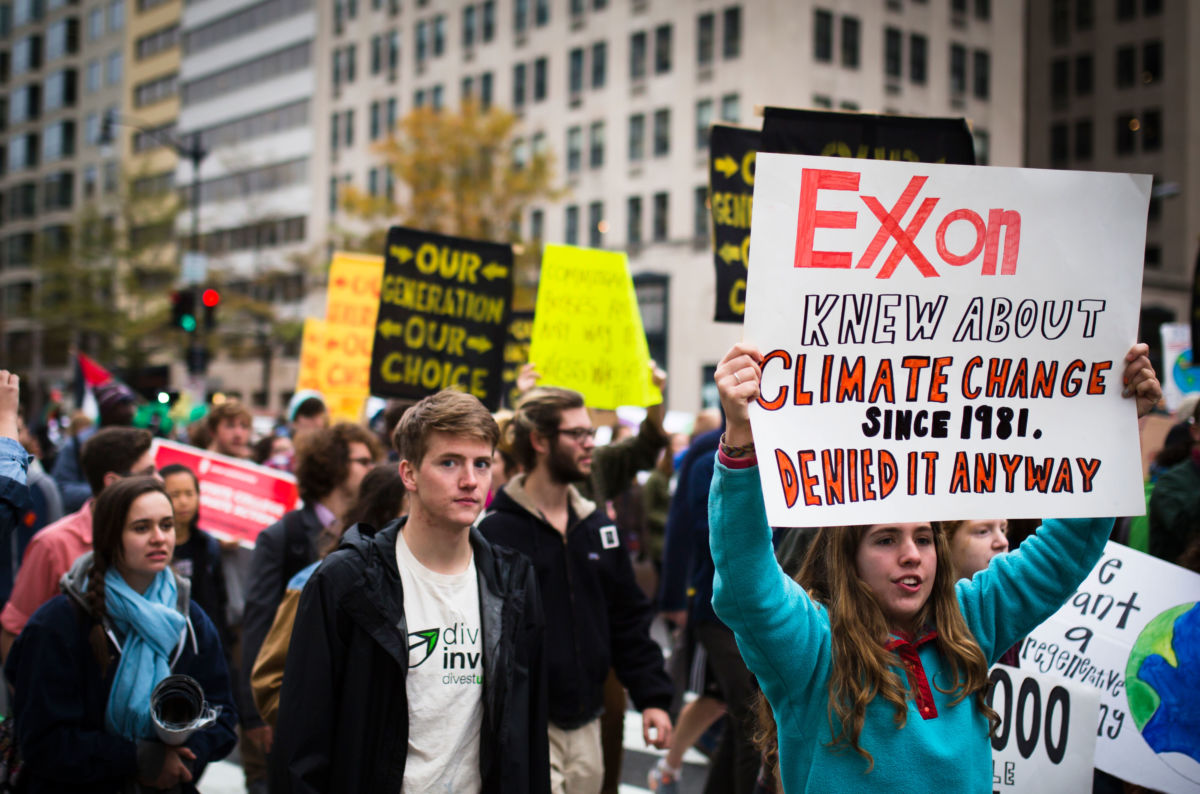 Protesters march while displaying signs