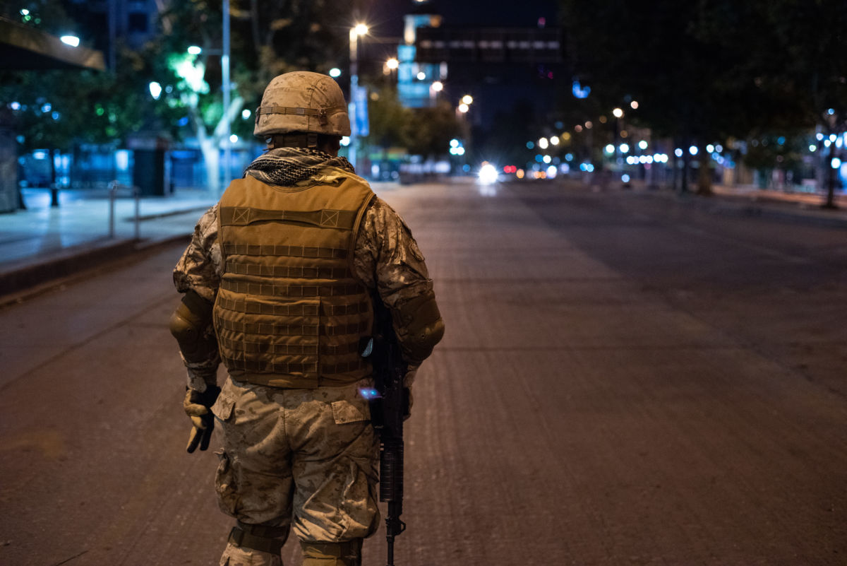 A soldier stands in the middle of a vacated street