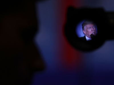 Donald Trump's face is seen through the viewfinder of a camera